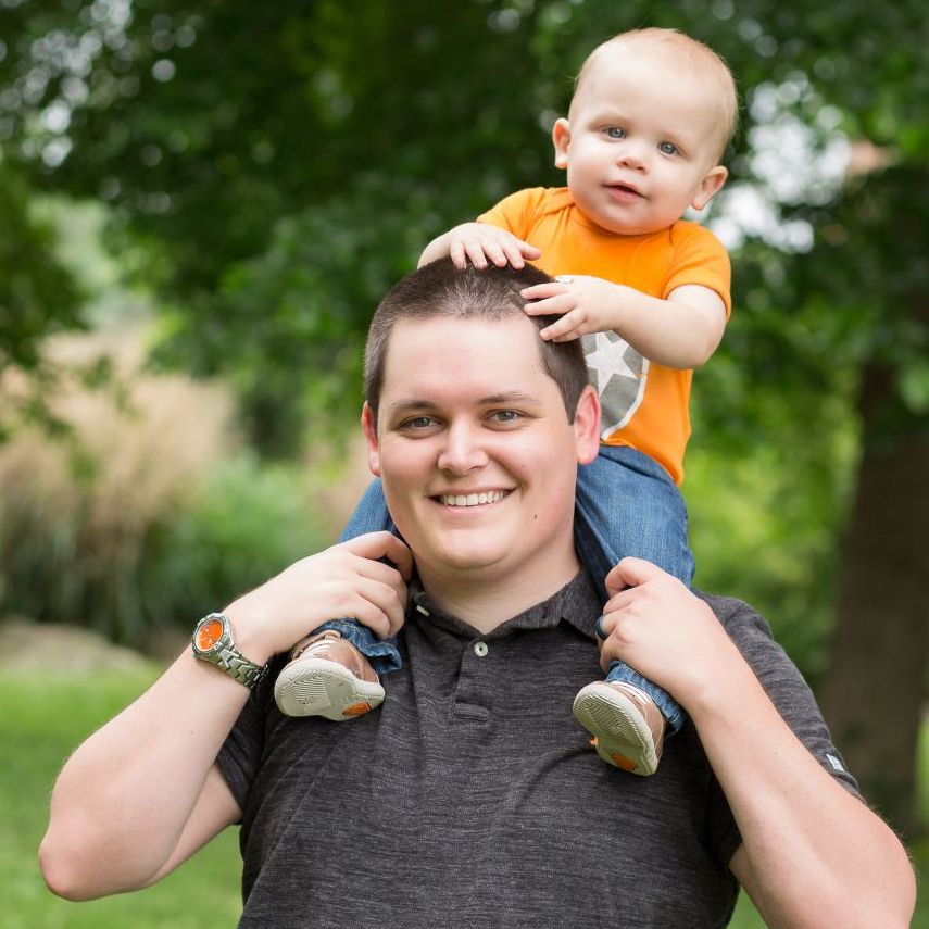 Photo of Bobby and his son Owen outside. Owen is sitting on Bobby's shoulders with his hands on Bobby's head.