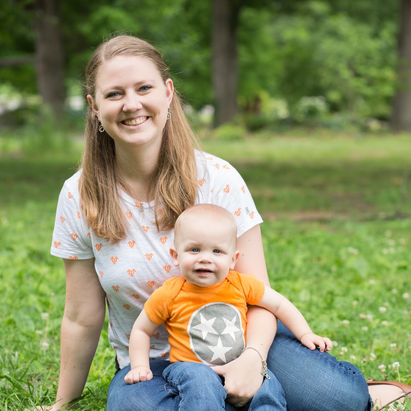 Photo of Stephanie and her son Owen outside. They're sitting on the ground with Owen in Stephanie's lap.