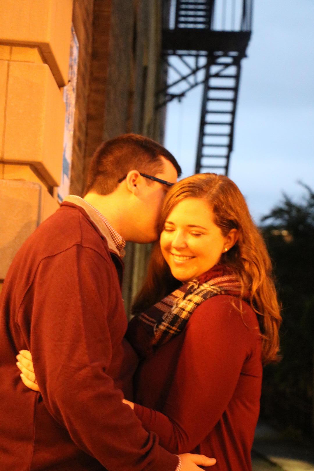 Sean kisses Haleigh's cheek on a street corner of Gay Street in downtown Knoxville, Tennessee
