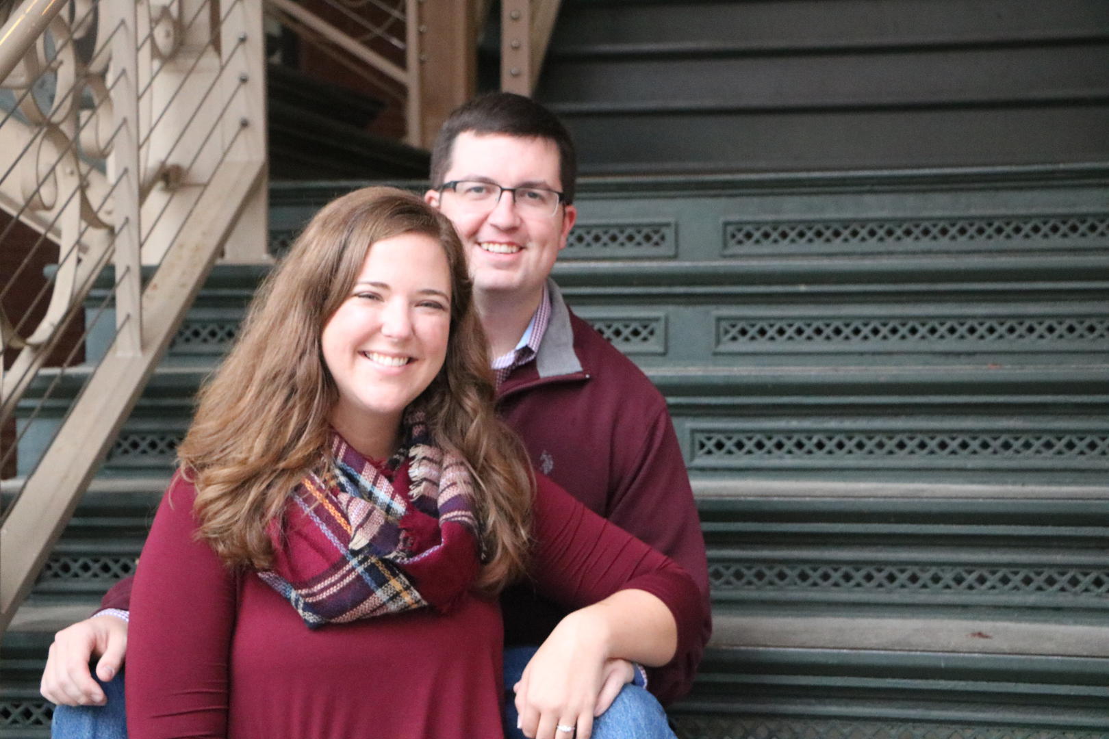 Haleigh and Sean sitting on a flight of ornate stairs
