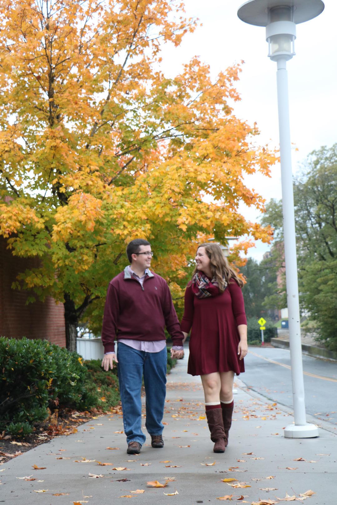 Haleigh and Sean walking along a sidewalk while holding hands
